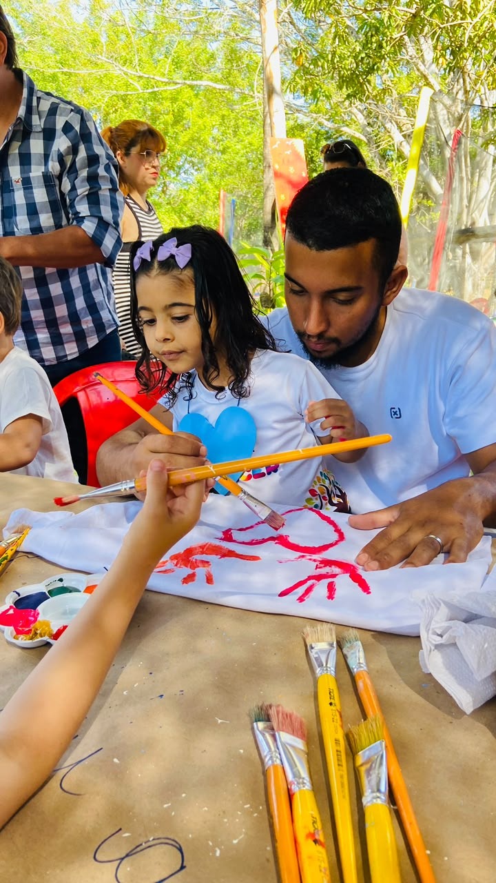 Criança pintando em atividade com um familiar