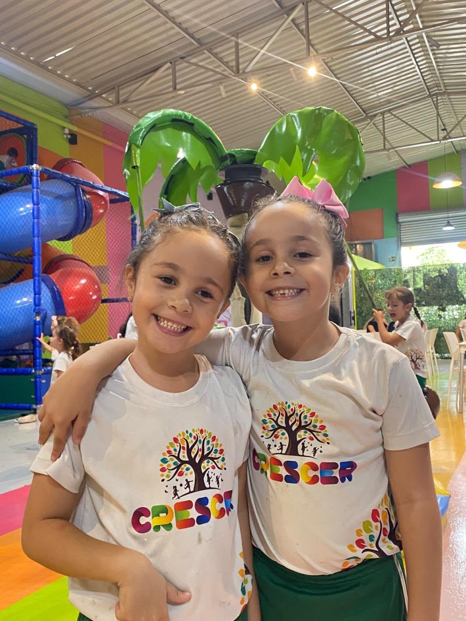 Duas alunas da Escola Crescer sorrindo durante uma atividade